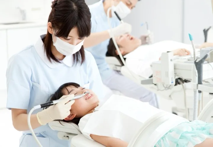 子どもの治療にあたる歯科医師と歯科衛生士