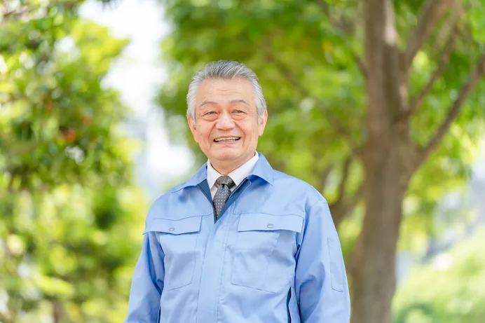 作業着姿で笑顔を見せるベテラン職人