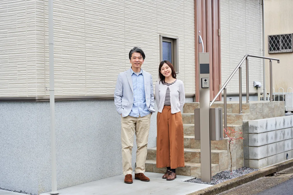 完成した住宅の玄関前に立つご夫婦