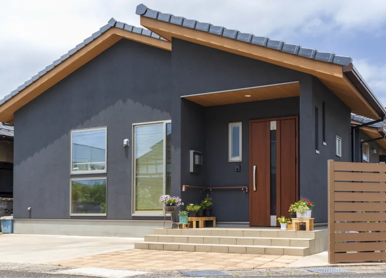 濃紺の外壁と木の軒天が印象的な切妻屋根の平屋